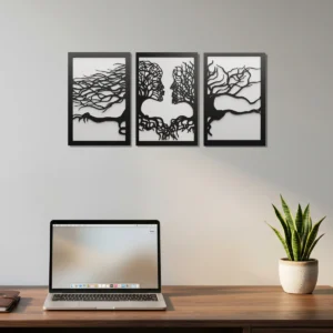Conjunto de três quadros decorativos com duas camadas em MDF na cor preto e branco, com o desenho vazado de árvore temática de casal, decorando a parede de um escritório moderno.