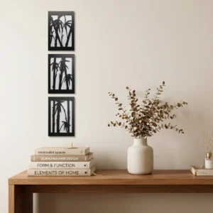 Conjunto de três quadros decorativos em MDF com duas camadas, com desenhos vazados de caules de bambu na cor preto e branco, instalados na parede de um escritório moderno.