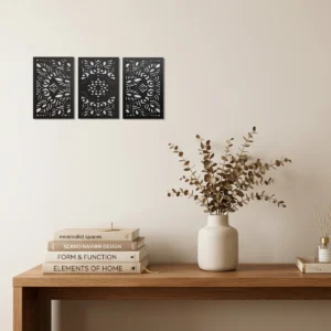 Conjunto de três quadros decorativos com desenho floral vazado branco em MDF, decorando uma parede de escritório.
